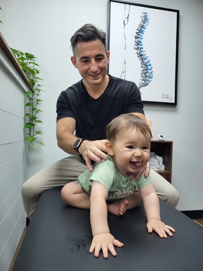 dr sebastian performing a chiropractic assessment on a pediatric patient
