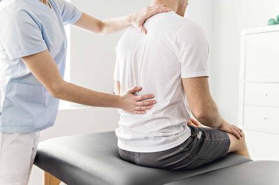 tampa chiropractor touching point of pain on male patients lower back